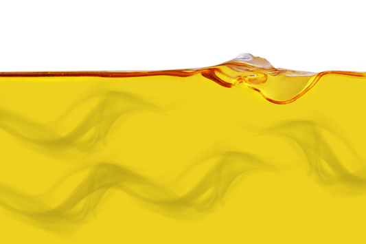 Close-up of golden cannabis-infused oil with cloudy swirls, representing filtration or infusion clarity issues.